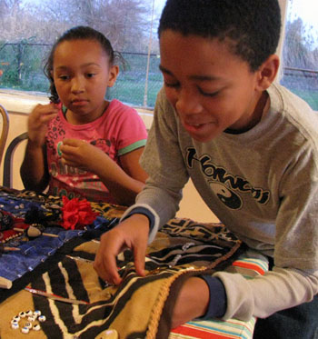 Aviana Dent, 7, and Tyrell Jamerson, 11, work on the Black Watermen of the Chesapeake quilt. CNS photo by Catherine Krikstan.